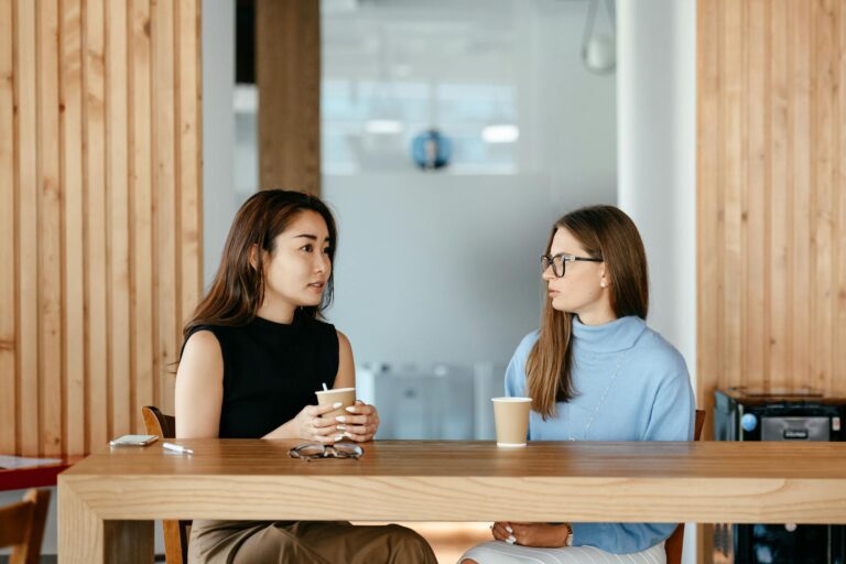 diverse women talking during coffee break at table