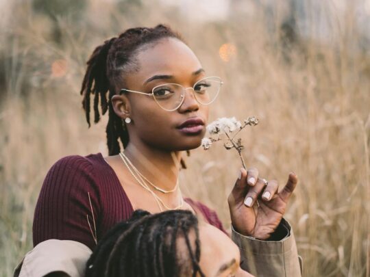 man and woman surrounded by grass