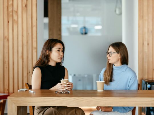 diverse women talking during coffee break at table